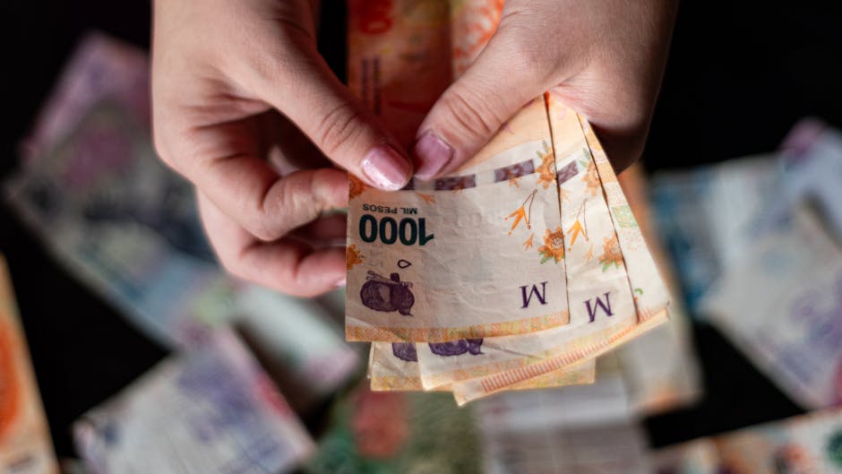 A person counting Argentine peso banknotes, showcasing the national currency.