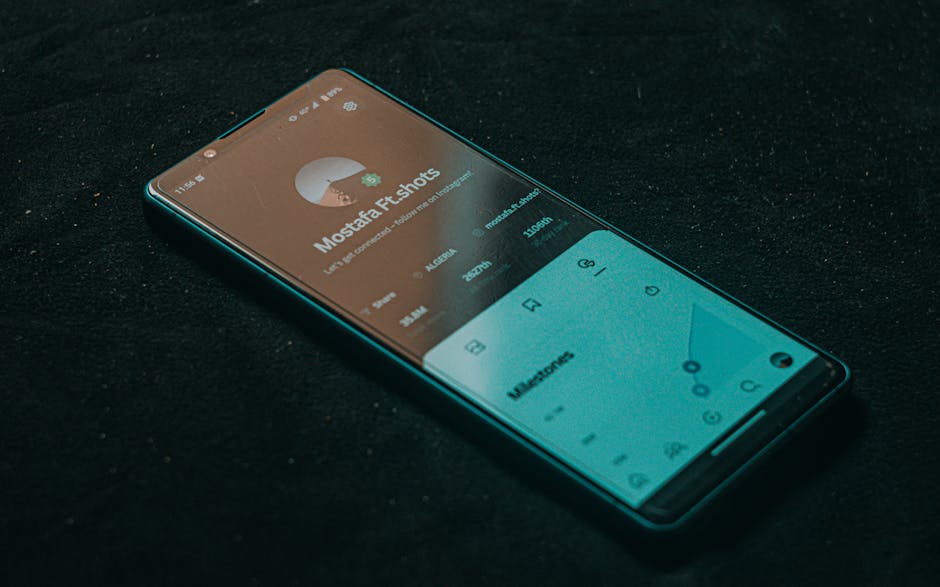 A smartphone displaying an app screen lies on a dark surface, highlighting technology.